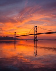 Fototapeta premium Golden Sunset Over Suspension Bridge with Dramatic Sky Reflection and Serene Water Landscape Background 
