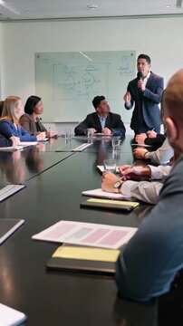 Professional coach presenting and engaging with future business managers during a workshop in a conference room, vertical shot