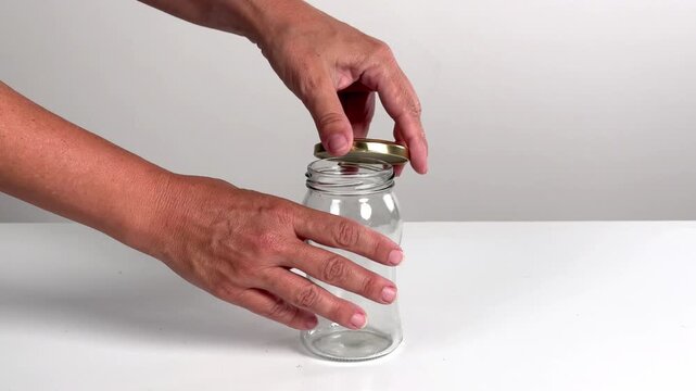 Video with real sound effect of Metal lid screwing onto glass jar.
