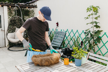 One person plants flowers in an eco-pot in the backyard.
