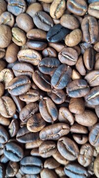 Roasted Arabica Coffee Beans with Uneven Roasting Levels and Some Slightly Burned Beans Background