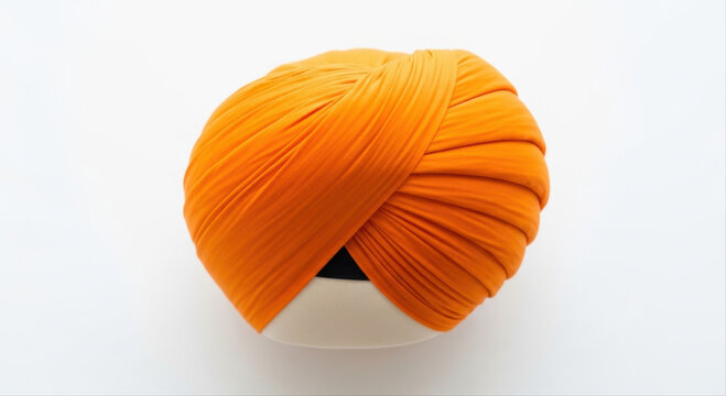 Vibrant orange Sikh turban elegantly displayed isolated on a pristine white background, showcasing intricate folds and cultural significance