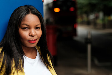 Confident young black woman posing in urban setting with red lipstick