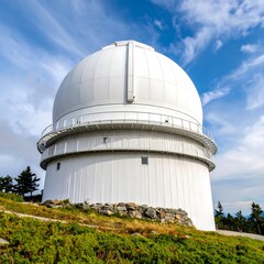 A large white astronomical observatory dome on a hill