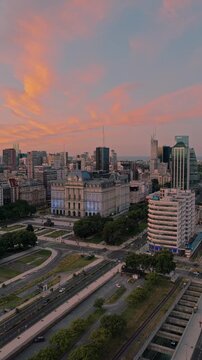 Vertical aerial pan right revealing Palacio Libertad, former CCK, surrounded by downtown Buenos Aires architecture during sunset and warm evening light.