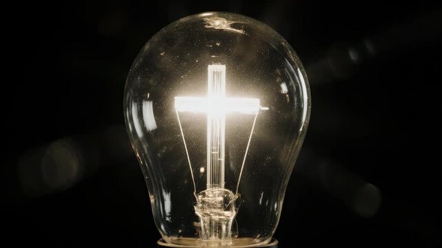 A light bulb in a dark background with a Christian cross.