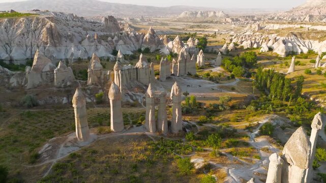 Goreme, Nevsehir, Turkey. Intimate low flight over Love Valley trails with close view of unique rock formations during golden hour. Aerial View