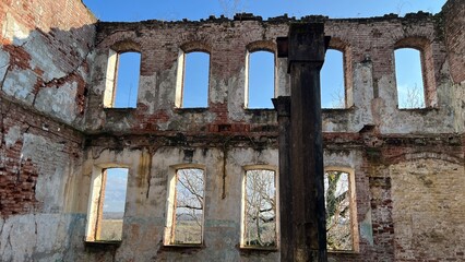 Obraz premium Interior of an abandoned brick building with empty windows and ruined walls.