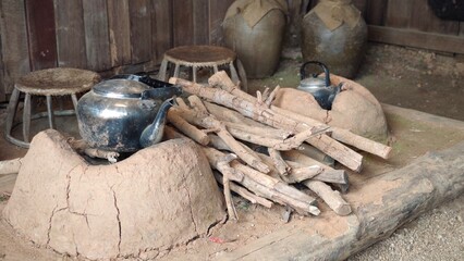 A blackened kettle on the stove with a smoldering fire underneath.