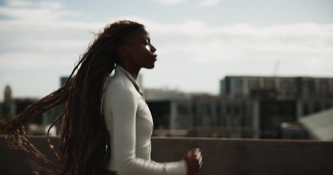 Running, fitness and black woman in city for cardio health, wellness or endurance training. Athlete, jog and person in urban town for sports, exercise or runner practice on bridge for workout outdoor