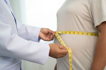 Asian woman with fat belly big size overweight and obesity with measure tape.