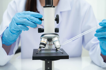 Scientist medical professional use microscope for research in science laboratory.