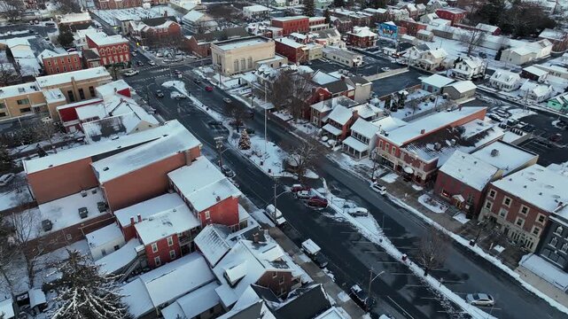 Historic American town in winter. Snow covering rooftops and streets as cars driving on town center street. Classic architecture and quiet seasonal atmosphere in winter. Manheim, Pennsylvania.