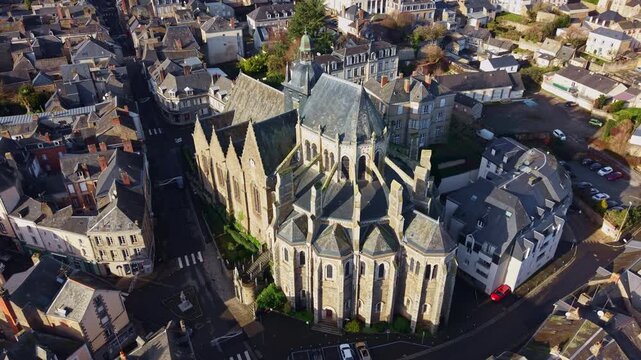 Historic gothic architecture of Basilica of Notre Dame of Miracles in town of Mayenne, France. Aerial drone circling
