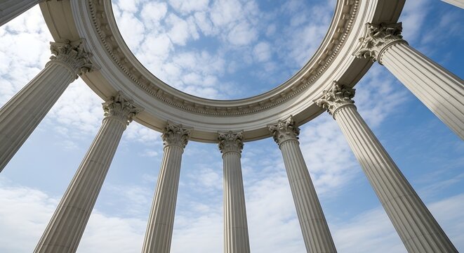 Majestic ancient columns reaching towards the blue sky with scattered clouds