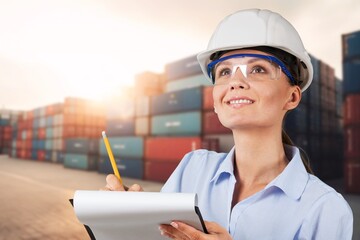 Female worker checking cargo at big container yard.