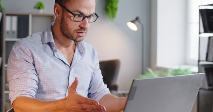 Man laptop stress frustration online work problem. Upset adult reacts to error on video chat, facing failed task and client anger, showing burnout and tension. Concept of online work stress.