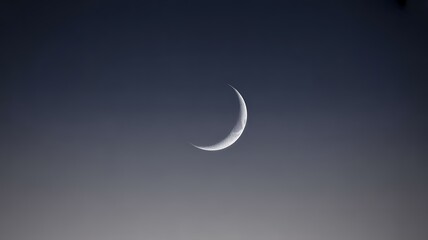 Title: Thin Crescent Moon in Clear Evening Sky
