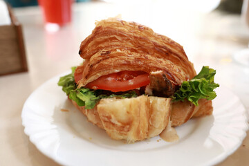 Fresh croissant sandwich with lettuce and tomato