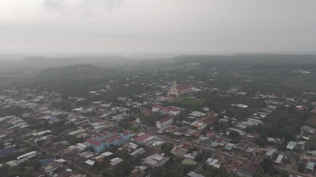Aerial view of rural church surrounded by residential houses and countryside landscape, peaceful community scene in Vietnam