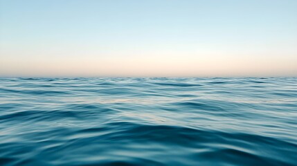 Obraz premium Calm ocean surface at sunrise with soft sky gradient