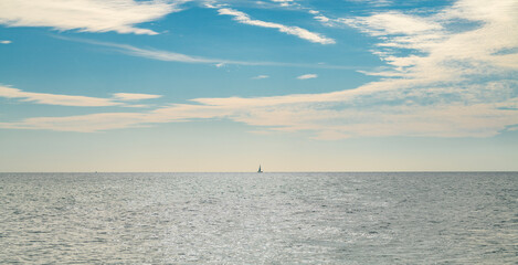 Fototapeta premium Sea with calm summer sky background. Sea with soft clouds. Sea calm tranquil water. Sea quiet background.