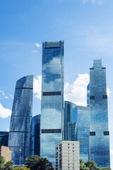 Obraz premium City buildings reflect sunlight in Moscow City with clouds in the sky