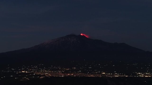 Mount Etna erupting volcanic summit glowing deep red lava above Catania city at night