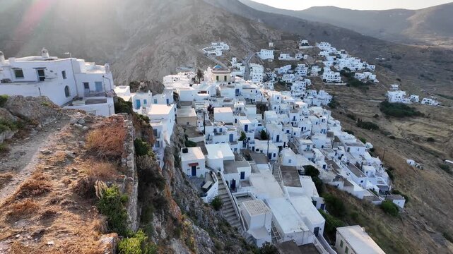 Serifos Island,Aerial view tilt down of the Hora with white houses,hills and sunken sun at the back ground.