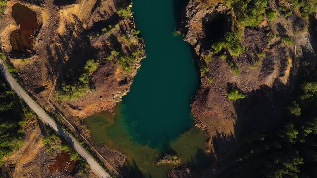 Top down drone shot over a turquoise lake, copper ore, in sunny Orajarvi, Finland