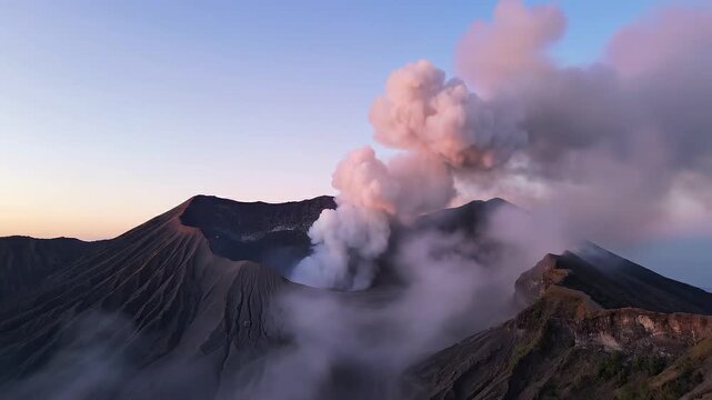 Cinematic aerial footage of active volcano bromo crater emitting massive steam plumes at sunset with epic mountain ridge motion