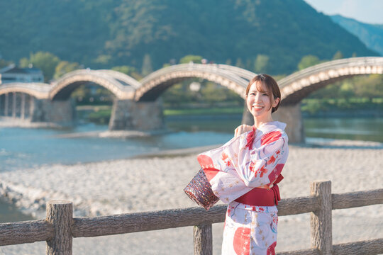 日本の山口県にある有名な建築物の錦帯橋と着物の浴衣を着た女性