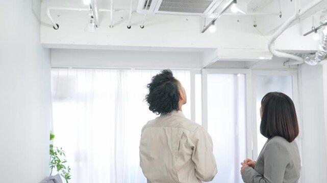オフィスの天井設備を点検する作業員