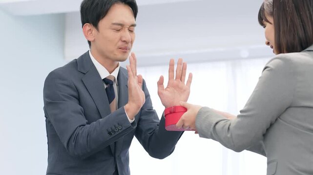 プレゼントを渡されて拒否するビジネスパーソン