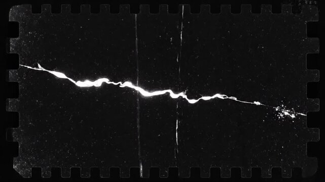 Black scratched film strip with bright light streaks and dust