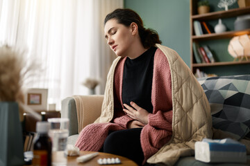 Obraz premium Woman Experiencing Stomach Pain at Home