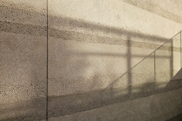 Abstract architectural background with sunlight and shadow on textured wall.