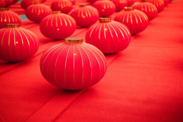 Rows of traditional red Chinese lanterns decorated on red carpet background. Lunar New Year celebration and Oriental festival decoration concept. Close up of round paper lanterns for Spring Festival.
