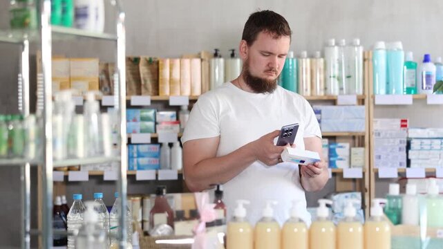 Young man buyer scanning qr code for box of ointment in pharmacy