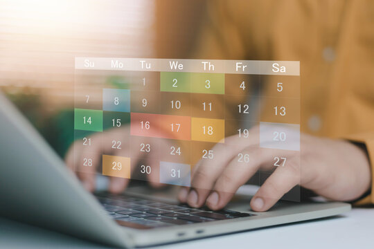Online calendar management concept with virtual monthly schedule over laptop keyboard. Business appointment planning, deadline tracking, time organization and digital productivity system.