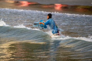 A Thai fisherman with a net catches fish in the coastal area on a sunny morning