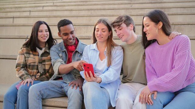 A cheerful group of teenagers enthusiastically enjoying a smartphone together, showcasing their friendship and connection through shared experiences and digital interactions among peers.