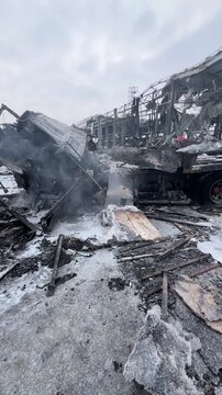 A large truck burned down at the site of the missile attack. A large car turned into a chest metal. Smoke comes out of the mutilated car after the fire.