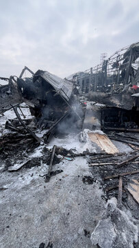 A large truck burned down at the site of the missile attack. A large car turned into a chest metal. Smoke comes out of the mutilated car after the fire.