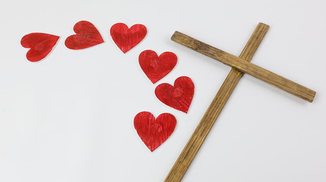 Una croce di legno con cuori rossi. Concetto di San Valentino con spazio vuoto per scrivere un biglietto d'amore