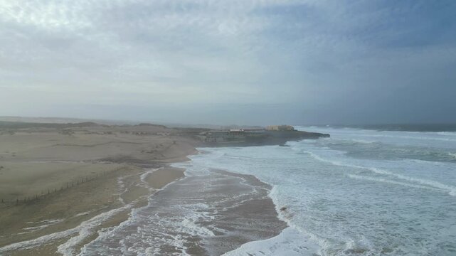 Flying over Guincho beach, damaged by Storm Kristin,we can observe the erosion of the sand and the force of the sea with its white color..Guincho beach,Cascais,Portugal