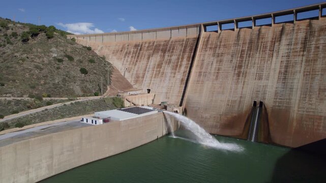 Water outlet from dam wall. Howell Bunger valve in operation. Pressurized water outlet from dam wall. Water flowing from pumping in reservoir. Hydropower station pumping water.