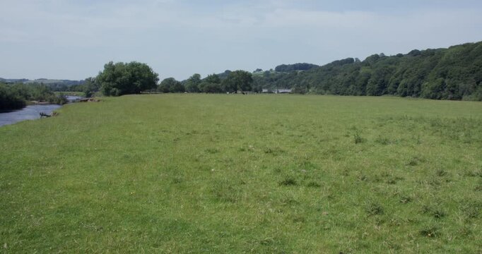 Extra wide shot of a Meadow next to the river Lune with Thirlmere aqueduct waterworks in background