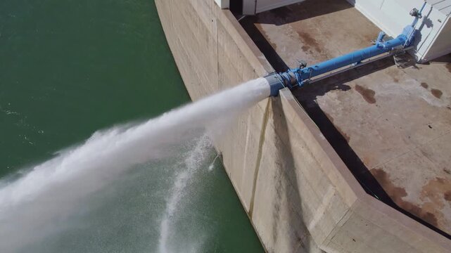 Water outlet from dam wall. Howell Bunger valve in operation. Pressurized water outlet from dam wall. Water flowing from pumping in reservoir. Hydropower station pumping water.