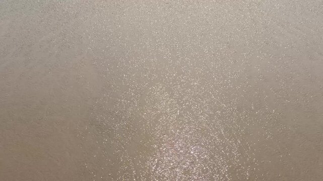 Water from sea waves going back to see after hitting the beach
